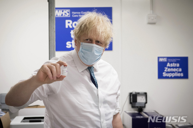 [런던=뉴시스/AP] 보리스 존슨 영국 총리가 25일 런던의 코로나바이러스 예방접종센터인 하이브의 바넷 FC 그라운드를 방문한 자리에서 옥스퍼드 아스트라제네카 코로나바이러스 백신 접종을 들고 있다.