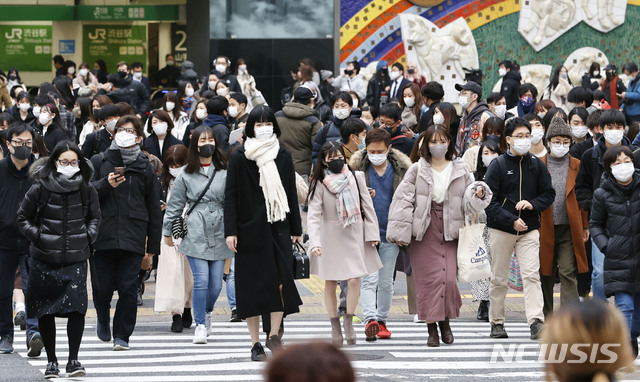 [도쿄=AP/뉴시스] 지난달 24일 일본 도쿄에서 코로나19 확산 방지를 위해 마스크를 쓴 시민들이 교차로를 건너고 있다.