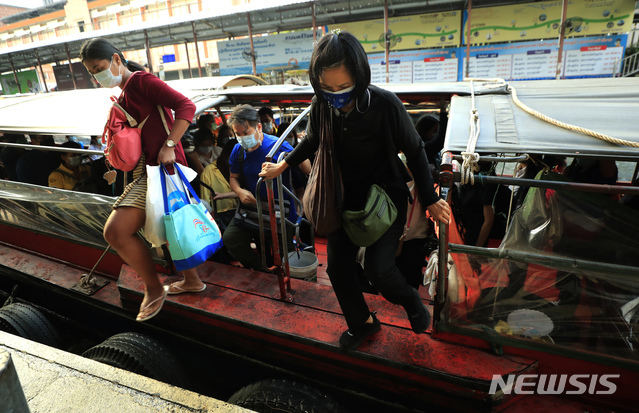[방콕=AP/뉴시스]11일 태국 방콕 샌샙 운하 부두에서 코로나19 예방을 위해 마스크를 쓴 승객들이 하선하고 있다.
