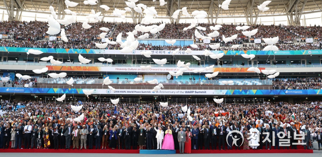 2018년 9월 18일 인천 아시아드 주경기장에서 ‘9.18 평화 만국회의 4주년 기념식’이 열린 가운데 참석자들이 평화의 상징인 비둘기 모양 풍선을 함께 날리며 단체사진을 찍고 있다. ⓒ천지일보DB