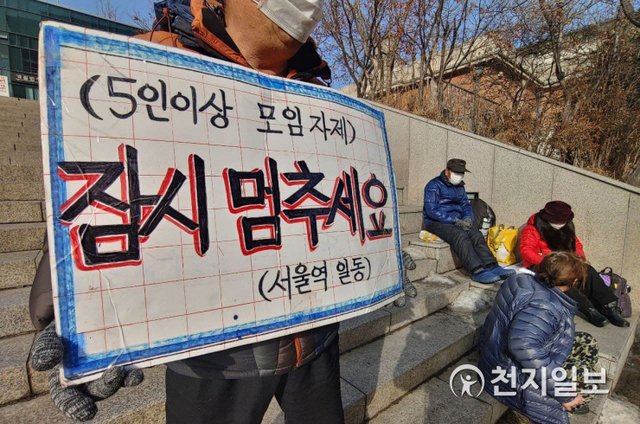 [천지일보=남승우 기자] 14일 서울역 광장에서 한 노숙인이 ‘5인이상 모임금지, 잠시 멈추세요’라는 문구가 적힌 피켓을 들고 있다. ⓒ천지일보 2021.1.14