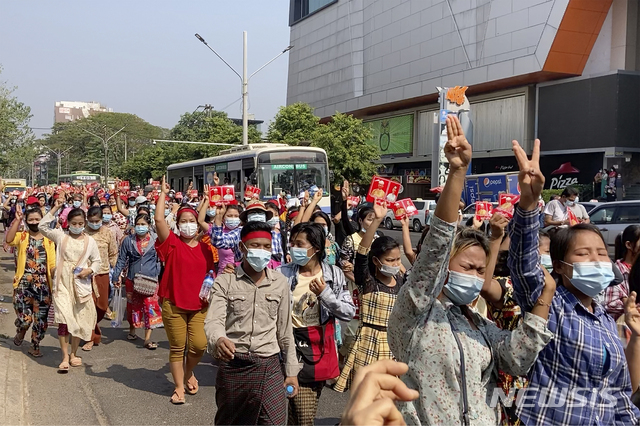 6일(현지시간) 미얀마 양곤에서 수천명의 시민이 군부 쿠데타에 항의하기 위해 시위를 벌이는 가운데 수치 고문의 민주주의민족동맹(NLD)당을 상징하는 붉은색 리본을 팔목에 묶거나 머리에 두르고 저항의 상징인 세 손가락 경례를 하고 있다. (출처: 뉴시스)