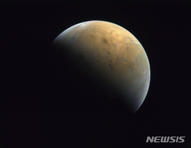 [AP/뉴시스] 아랍에미리트연합의 화성 궤도순항 탐사선 아말이 궤도진입 하루 뒤인 10일 찍어 보낸 화성 모습. 화성이 자전하면서 태양빛에 의해 밤과 낮이 갈라지고 있다. 낮이 된 윗부분에 '3 방패화산'이 일렬로 서있다.