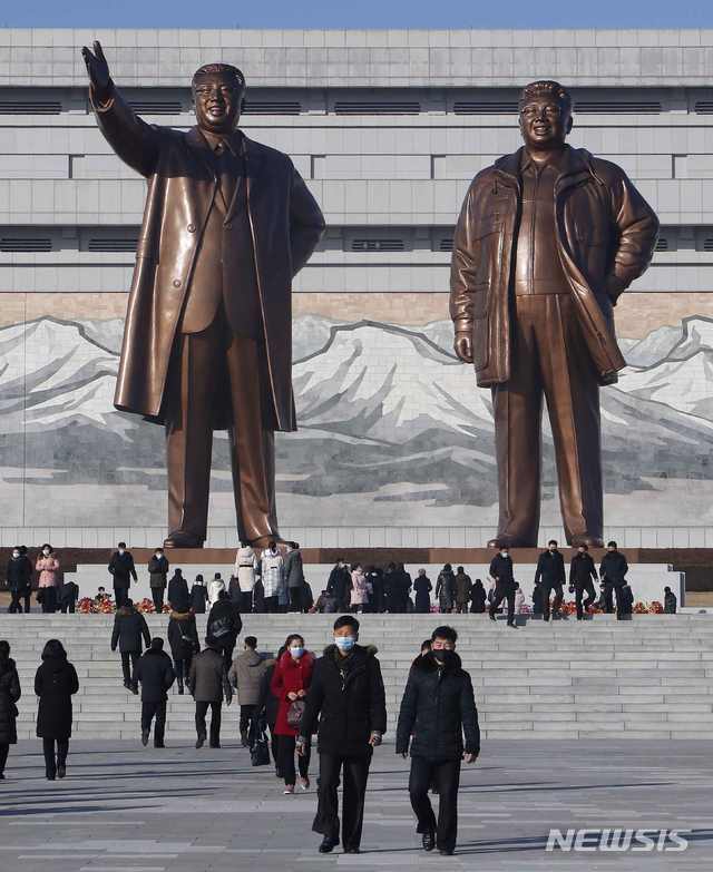 [평양=AP/뉴시스] 새해 첫날인 1일 북한 평양 주민들이 만수대를 찾아 김일성 김정일 부자 동상 앞에 화환을 바치고 있다.