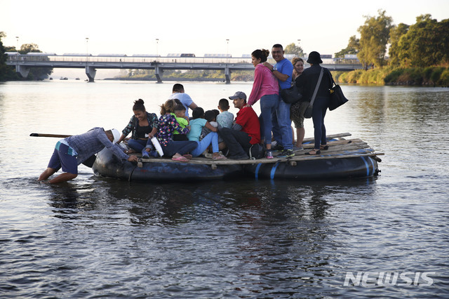 【시우다드이달고(멕시코)=AP/뉴시스】미국 국경으로 향하는 온두라스 이민자들이 18일(현지시간) 뗏목을 타고 멕시코 시우다드 이달고의 과테말라와의 접경 구역인 수치아테 강을 건너 멕시코로 향하고 있다.