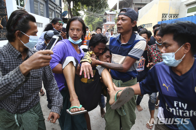 20일 미얀마 제2도시 만달레이에서 군부 쿠데타에 항의하는 시위에 참여한 한 남성이 군경이 쏜 총에 맞아 실려가고 있다. 2020.02.20. (출처: 뉴시스)