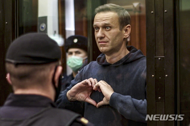 [모스크바=AP/뉴시스] 러시아 야권 운동가 알렉세이 나발니가 2일(현지시간) 모스크바 법원에서 열린 집행유예 판결 취소 공판 중 하트를 보내고 있다. 모스크바 법원이 나발니에 대한 집행유예 판결 취소 공판에서 3년 6개월의 실형을 선고했다. 이에 따라 나발니는 가택 연금됐던 1년을 제외한 2년 6개월을 교도소에서 복역하게 됐다.