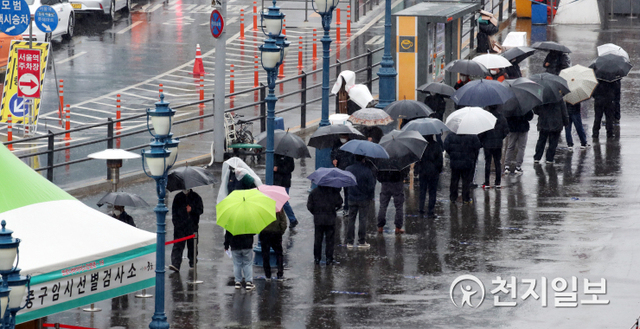 [천지일보=박준성 기자] 비가 내리는 1일 오후 서울역 광장에 마련된 신종 코로나바이러스 감염증(코로나19) 임시선별진료소에서 시민들이 검사를 받기 위해 긴 줄을 서서 대기하고 있다. ⓒ천지일보 2021.3.1