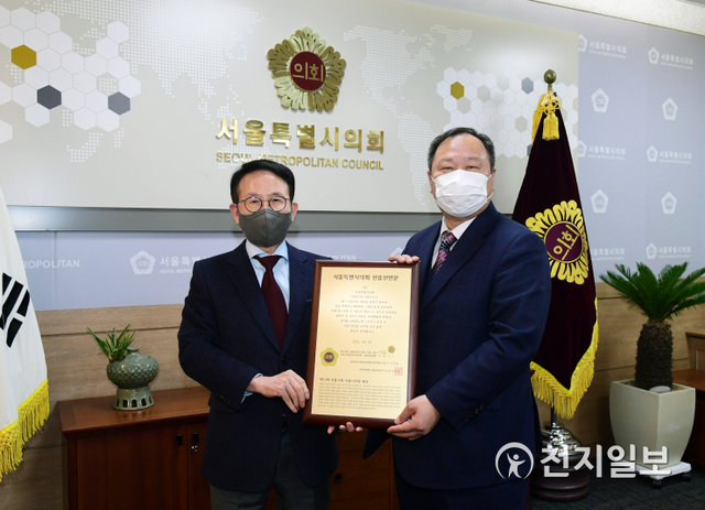 민병철 선플재단 이사장(왼쪽)이 김인호 서울시의회 의장에게 선플서명에 참여한 서울시의원 108명의 명단이 새겨진 동판을 전달하고 있다. (제공: 선플재단) ⓒ천지일보 2021.3.5
