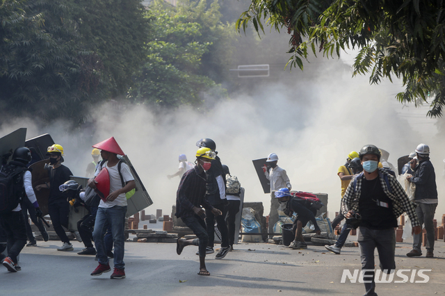 3일 미얀마 만달레이에서 군부 쿠데타에 반대하는 시위대가 군경이 쏜 최루탄을 피해 달리고 있다. 2021.03.03. (출처: 뉴시스)