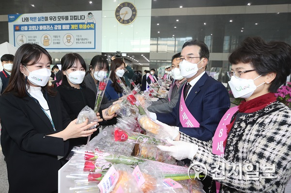 이성희 농협중앙회장(오른쪽에서 두번째)이 8일 ‘세계 여성의 날’을 맞아 서울 중구 농협중앙회 본관에서 출근하는 직원들에게 장미꽃과 우리 쌀빵을 나줘주고 있다. (제공: 농협) ⓒ천지일보 2021.3.8