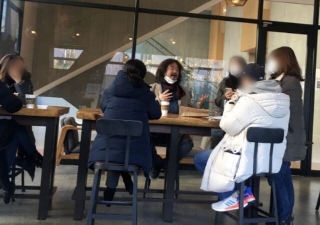 TBS 김어준의 뉴스공장 진행자인 김어준씨가 지난 1월 19일 서울 마포구 상암동 한 카페에서 마스크를 턱에 걸친 채 일행들과 이야기 하고 있다. (출처: 온라인 커뮤니티 캡쳐)