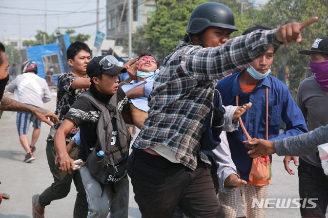 지난 22일 미얀마 만달레이에서 군부 쿠데타 반대 시위가 벌어진 가운데 한 남성이 머리에 부상을 입고 실려가고 있다. (출처: 뉴시스)