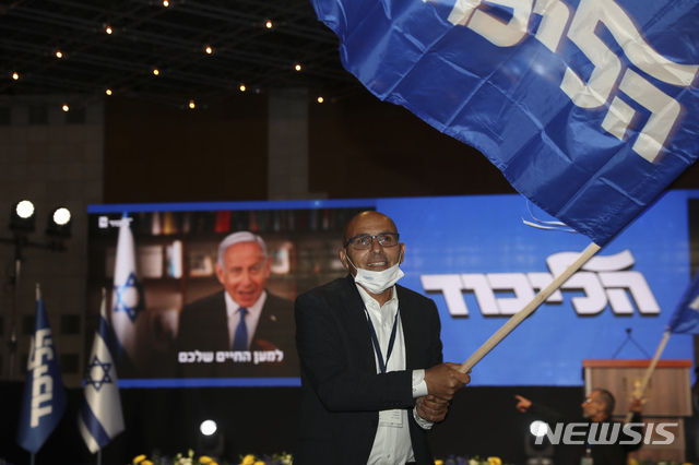 [ 예루살렘 = AP/뉴시스] 23일 치러진 이스라엘 총선에서 베냐민 네타냐후 총리의 지지자가 출구조사를 앞두고 그의 리쿠드당 깃발을 흔들며 지지를 표하고있다.