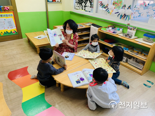 군산시의 어린이집 선생님이 아이들에게 코로나19를 이해하고 예방할 수 있도록 동화책을 읽어 주며 교육하고 있다. (제공: 군산시청) ⓒ천지일보 2021.2.19