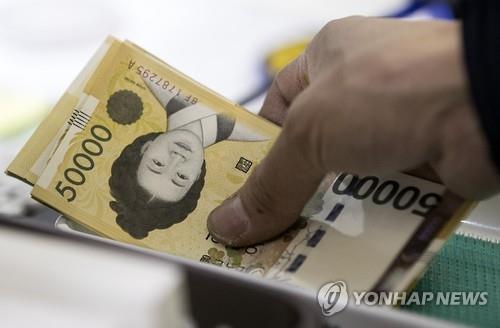 은행에서 빳빳한 새 5만원권 지폐를 찾고 있는 모습 (출처: 연합뉴스)