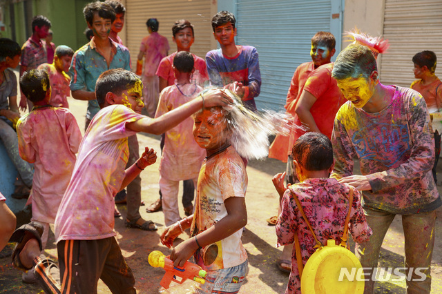 [하이데라바드=AP/뉴시스]29일(현지시간) 인도 하이데라바드에서 주민들이 홀리 축제를 맞아 서로에게 색 가루를 뿌리며 즐거워하고 있다. 28일 시작한 색채 축제 '홀리'는 힌두교 전통 봄맞이 축제다.