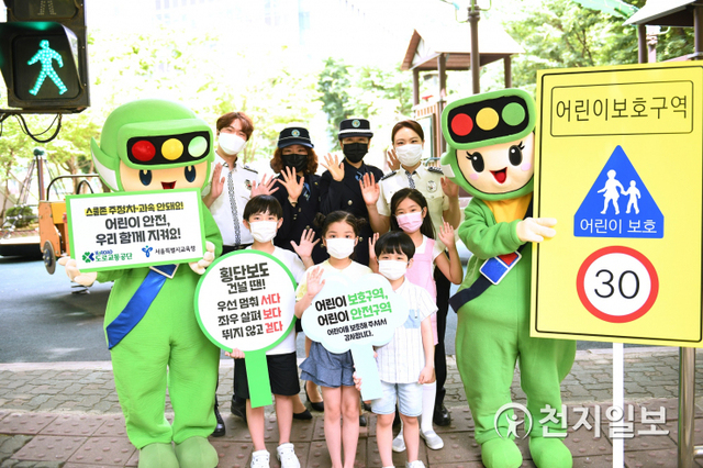 어린이들이 경찰관, 서울녹색어머니연합, 도로교통공단 교통안전교육지도사와 함께 어린이보호구역 교통안전을 위한 사진을 촬영하고 있다. (제공: 도로교통공단) ⓒ천지일보 2021.4.14