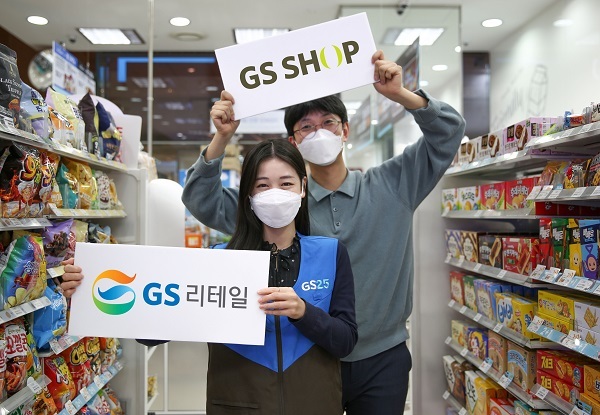 남녀 모델이 GS리테일과 GS홈쇼핑의 홍보물을 들고 포즈를 취하고 있다. (제공: GS리테일)
