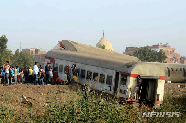 탈선으로 선로 벗어난 이집트 열차[카이로=AP/뉴시스] 18일(현지시간) 이집트 수도 카이로 북쪽 칼류비아주 반하에서 여객열차가 탈선하는 사고가 나 현장에 사람들이 모여 있다. 현지 당국은 이 사고로 최소 11명이 숨지고 100명이 다쳤다고 전했다.
