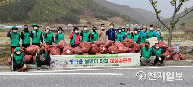 정선군 새마을회 회원들이 20일 정선군 북평면 나전중학교 앞 골지천 일원에서 겨우내 방치됐던 각종 쓰레기를 수거하는 등 자연정화 활동을 마치고 기념촬영을 하고 있다. (제공: 정선군청) ⓒ천지일보 2021.4.20