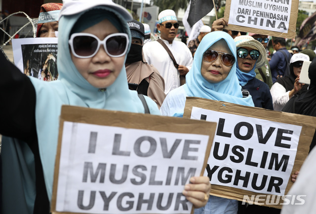 [자카르타=AP/뉴시스] 27일(현지시간) 인도네시아 자카르타 주재 중국 대사관 앞에서 무슬림 여성들이 손팻말을  들고 시위를 벌이고 있다.