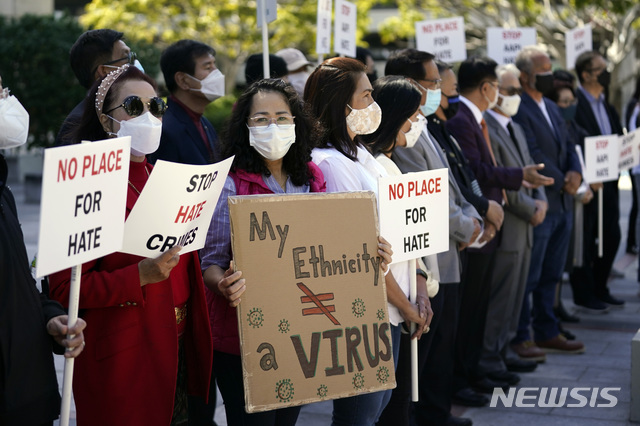 [로스앤젤레스=AP/뉴시스]22일(현지시간) 미 캘리포니아주 로스앤젤레스에서 열린 아시아계 미국인에 대한 폭력 중단 촉구 기자회견에 참석한 시위대가 '증오 범죄 중단'이라고 쓰인 팻말을 들고 있다.