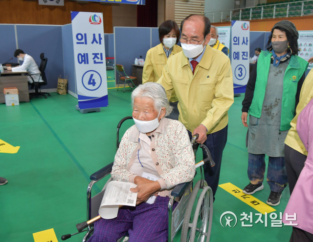 이승율 청도군수이 국민체육센터 실내체육관에 설치된 예방접종센터에서 어르신 휠체어를 밀어주고 있다. (제공: 경북 청도군) ⓒ천지일보 2021.4.28