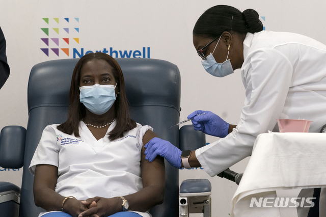 [퀸스=AP/뉴시스] 14일(현지시간) 뉴욕 퀸스의 중환자실 간호사 샌드라 린지가 미국에서 최초로 신종 코로나바이러스 감염증(코로나19) 백신을 맞고 있다.
