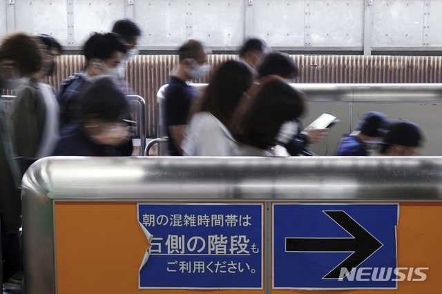 [도쿄=AP/뉴시스] 일본 수도 도쿄에서 7일간 연휴 '황금주일' 첫날인 30일 코로나19 예방을 위해 마스크를 착용한 시민들이 지하철을 내린 다음 출구 쪽으로 분주하게 움직이고 있다.