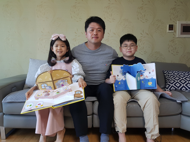 한화건설 직원이 자녀와 함께 복지기관에 전달할 팝업북을 만들고 있다. (제공: 한화건설)