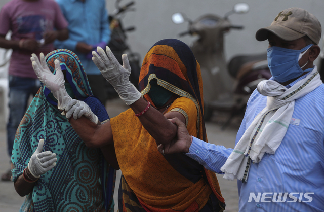 [아마다바드=AP/뉴시스]27일(현지시간) 인도 아마다바드에서 코로나19로 사망한 환자의 한 가족이 코로나19 전용 국립 병원 밖에서 울부짖고 있다.