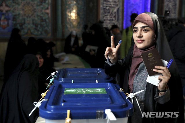 [테헤란=AP/뉴시스]21일(현지시간)  이란 수도 테헤란의 한 투표소에서 한 이란 여성이 투표를 마치고 인증샷을 찍고 있다.