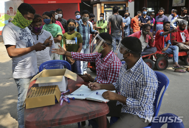 지난달 28일(현지시간) 인도 벵갈루루의 한 기차역 밖에서 여행객들이 코로나19 검사를 받기 전 신분을 확인하고 있다. (출처: 뉴시스)