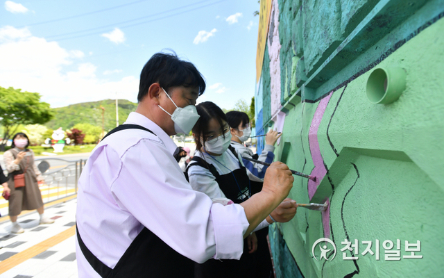 최문순 화천군수(맨 앞)와 지역 미술인, 학생들이 지난 9일 화천군 공공미술 프로젝트의 일환으로 화천중·고교 앞 옹벽에서 벽화를 그리고 있다. (제공: 화천군청) ⓒ천지일보 2021.5.10