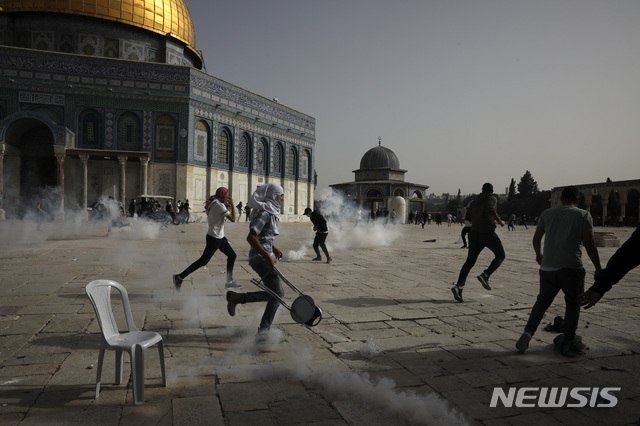 팔레스타인인들이 10일(현지시간) 동예루살렘 알 아크사 모스크에서 이스라엘 경찰과 충돌하는 가운데 최루탄을 피해 달아나고 있다. (출처: 뉴시스)