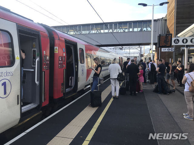 【피터버러=AP/뉴시스】 9일(현지시간) 영국 피터버러 역에서 정전으로 동부 해안으로 향하는 주 노선 운행이 중단된 가운데 승객들이 뉴스를 기다리고 있다.