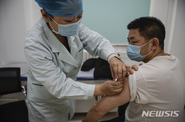 [베이징=AP/뉴시스] 2일 중국 베이징의 지정기관에서 한 남성이 시노팜(중국의약집단)에서 개발한 신종 코로나바이러스 감염증(코로나19) 백신을 접종하고 있다. 중국이 새해 첫날부터 자국 제약사인 시노팜이 발한 코로나19 백신 접종을 시작한 가운데 이틀만에 베이징에서만 7만회분의 접종됐다. 2020.01.04