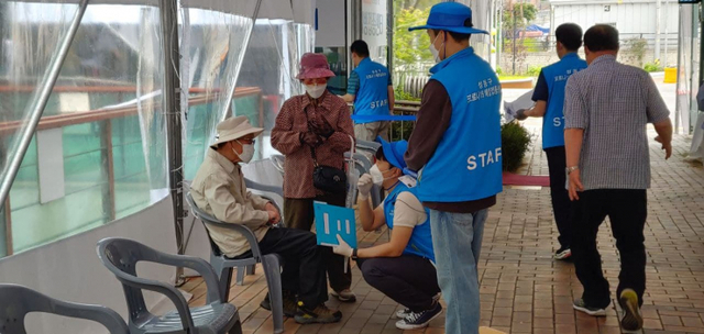 15일 서울 성동구청에 마련된 예방접종센터에서 75세 이상 백신 접종이 진행되는 가운데 관계자가 어르신에게 안내를 하고 있다. ⓒ천지일보 2021.5.15