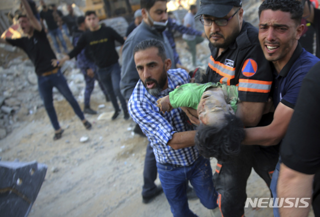 13일(현지시간) 가자지구 북부 베이트 라히아에서 이스라엘 공습 후 주민들이 다친 아이를 이송하고 있다. (출처: 뉴시스)