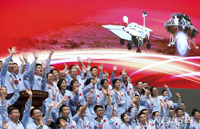 중국 베이징 항공우주관제센터 직원들이 중국의 무인 탐사선인 톈원 1호가 15일 성공적으로 화성에 착륙하자 축하하고 있다. (출처: 뉴시스)