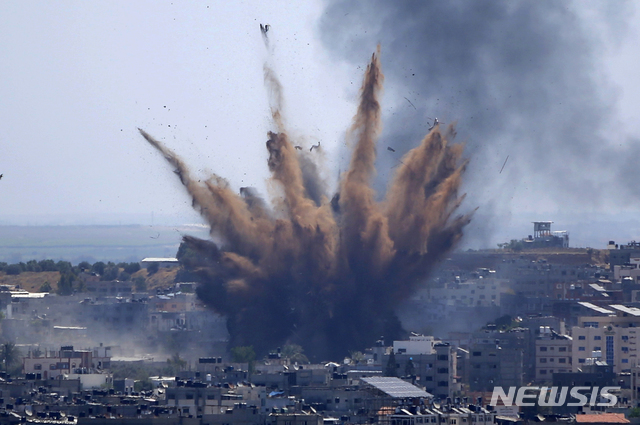 지난 13일(현지시간) 이스라엘 군의 폭격을 받은 가자지구 건물 위로 연기가 피어오르고 있다. (뉴시스)