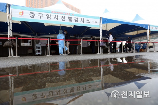 [천지일보=남승우 기자] 이슬비가 내리는 17일 오후 서울역 광장에 마련된 임시 선별검사소의 모습이 고인 빗물에 비치고 있다. 이날 신종 코로나바이러스 감염증(코로나19) 신규 확진자는 619명으로 집계됐다. ⓒ천지일보 2021.5.17