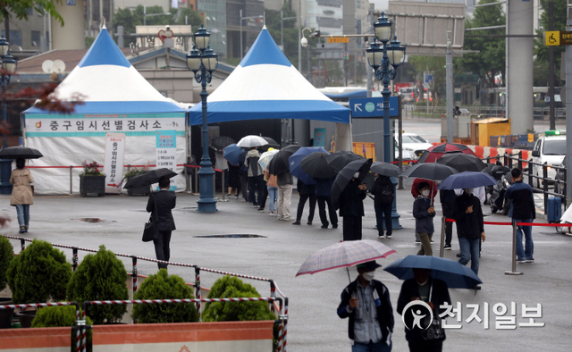 [천지일보=남승우 기자] 이슬비가 내리는 17일 오후 서울역 광장에 마련된 임시 선별검사소에서 시민들이 우산을 쓴 채 신종 코로나바이러스 감염증(코로나19) 검사를 받기 위해 줄을 서서 기다리고 있다. 이날 코로나19 신규 확진자는 619명으로 집계됐다. ⓒ천지일보 2021.5.17
