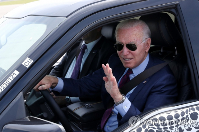 조 바이든 미국 대통령이 18일(현지시간) 미시간주 디어본의 포드 공장을 방문해 곧 출시될 신형 전기차 F-150 라이트닝 픽업트럭을 시승하며 손을 흔들고 있다. 바이든 대통령은 이날 연설을 통해 