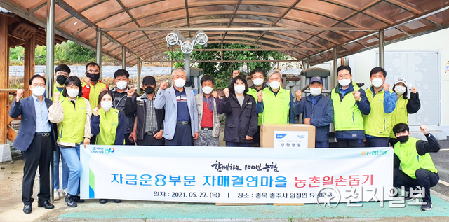 27일 유재도 NH농협은행 자금운용부문 부행장(오른쪽에서 다섯 번째)과 직원들이 충주시 엄정면 유봉리 자매결연마을에서 일손돕기에 앞서 기념촬영을 하고 있다. (제공: NH농협은행) ⓒ천지일보 2021.5.27