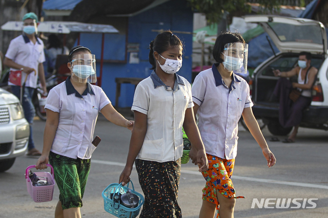 [양곤=AP/뉴시스]12일(현지시간) 미얀마 양곤 외곽의 흘라잉따야 공단에 마스크와 얼굴 가리개를 착용한 근로자들이 출근하고 있다.