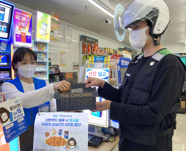 GS25 직원이 쏜살치킨을 전문 배달원에게 전달하고 있다. (제공: GS리테일)