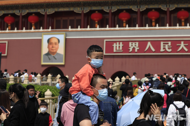 [베이징=AP/뉴시스] 지난 5월 3일 베이징 톈안먼광장에서 한 남성이 아이를 목마 태우고 걸어가고 있다.