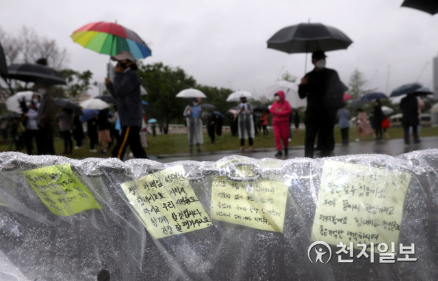 [천지일보=남승우 기자] 16일 오후 서울 서초구 반포한강공원 수상택시 승강장 인근에서 열린 고 손정민군을 위한 평화집회에서 시민들이 우산을 쓴 채 진상규명을 촉구하고 있다. ⓒ천지일보 2021.5.16